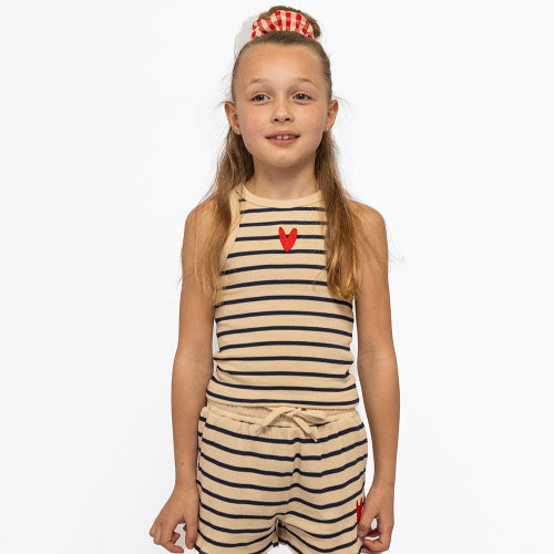 Young girl wearing a striped romper with a red heart design on a white background