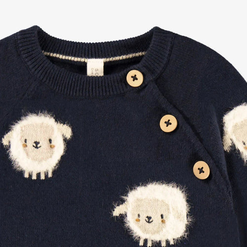 Navy sweater with white sheep designs and wooden buttons on a white background